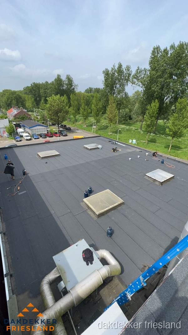 Dakdekker aan het werk op groot plat dak met bitumen in Friesland Dakdekker aan het werk op groot plat dak met bitumen in Friesland