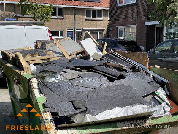 Afvalcontainer met gesloopt dakmateriaal tijdens dakkapel renovatie in Friesland Afvalcontainer met gesloopt dakmateriaal tijdens dakkapel renovatie in Friesland