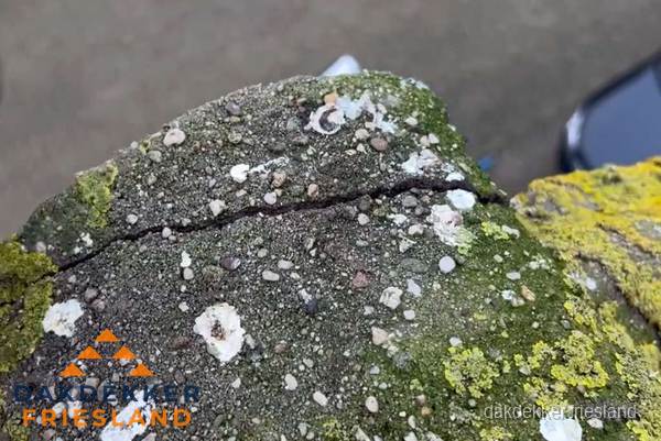 Beschadigde en verweerde nokvorst met scheuren en mos in Friesland
