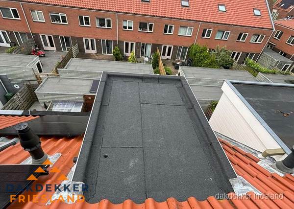 Plat dak met bitumen bedekking naast dakkapel in Friesland