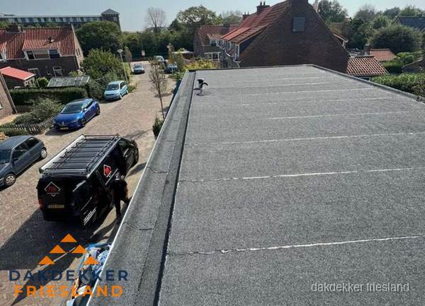 Nieuw bitumen plat dak met uitzicht over woonwijk in Friesland