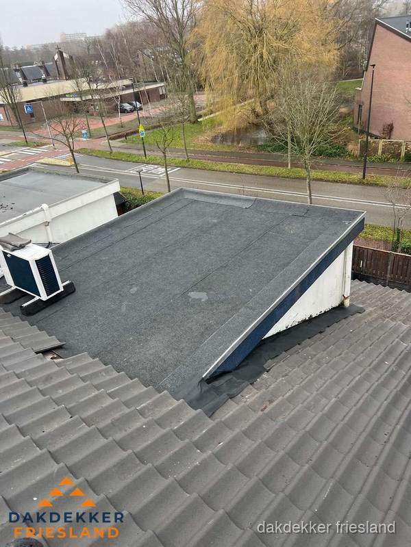 Plat dak met bitumen dakbedekking naast schuin pannendak in Friesland