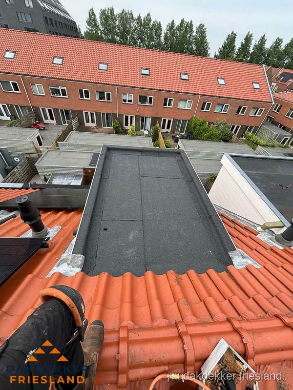 Bitumen dak reparatie op plat dak tussen dakpannen in Friesland