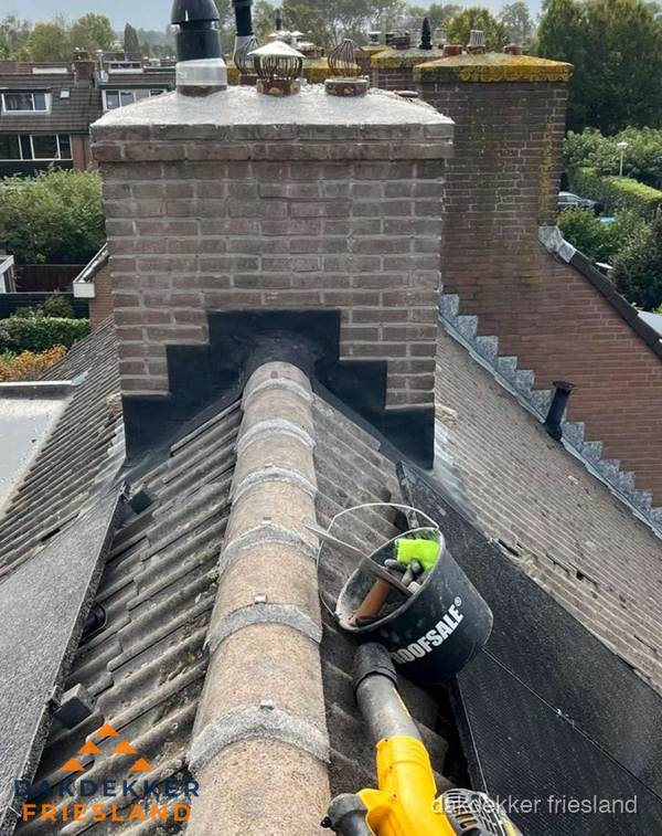 Schoorsteen met loodaansluiting en nokvorst op pannendak in Friesland