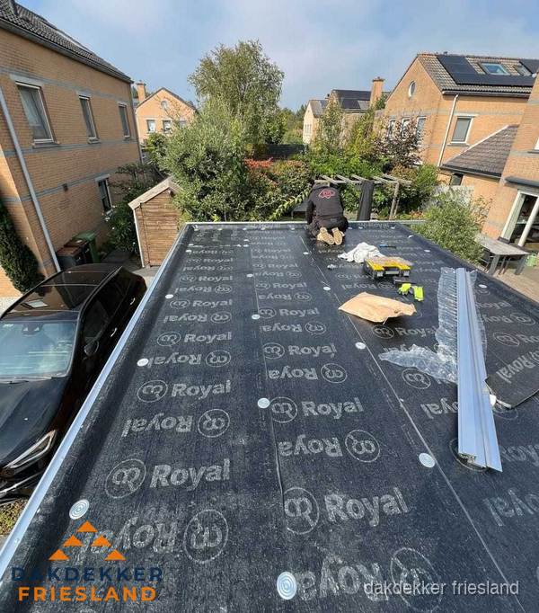 Dakdekker aan het werk op plat dak renovatie in Friesland