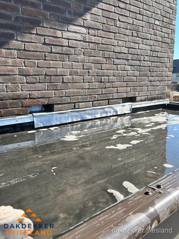 Stilstaand water op plat dak door slechte afwatering in Friesland Stilstaand water op plat dak door slechte afwatering in Friesland